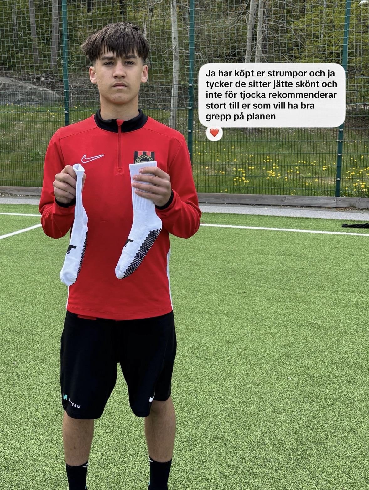 Ung fotbollsspelare på konstgräs håller upp ett par TEKKZ greppstrumpor – "Ja har köpt er strumpor och ja tycker de sitter jätte skönt och inte för tjocka rekommenderar stort till er som vill ha bra grepp på planen"